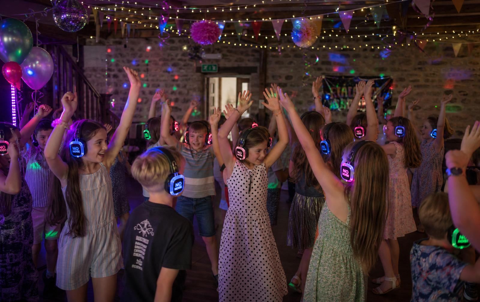 Kids silent disco party hire in Devon — children dancing in colourful LED headphones